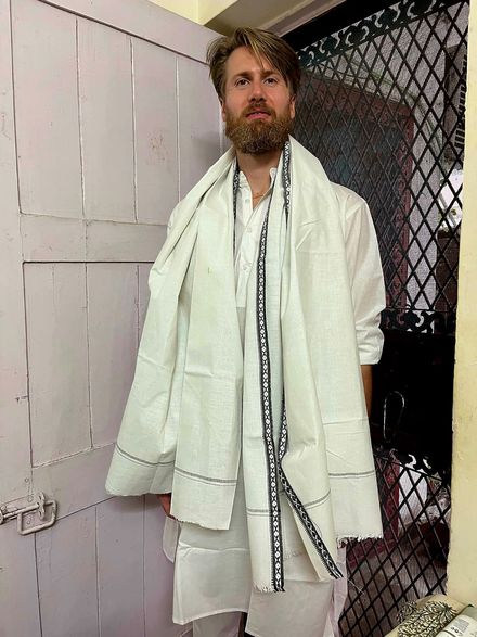 नए सफ़ेद कुर्ते और मेल खाते गमछे में Diederik